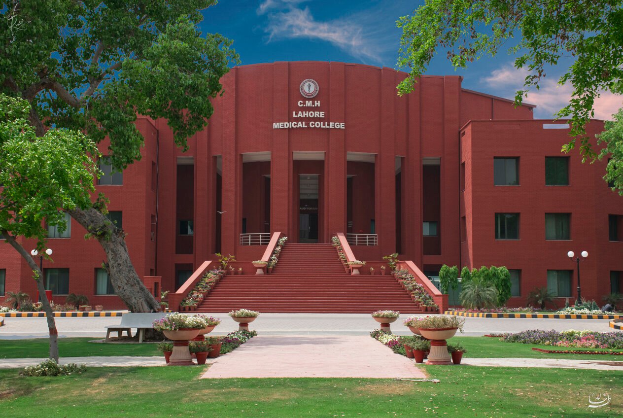 Red-brick main building of CMH Lahore Medical College with steps and flower beds